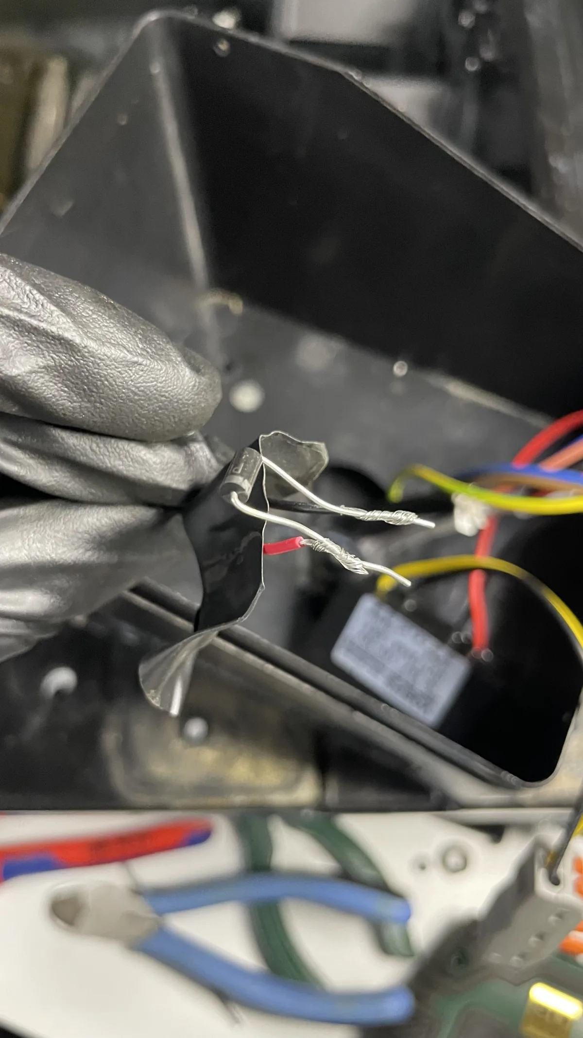 Unidentified axial component in a taped splice near the bath wiring, resembling a diode
