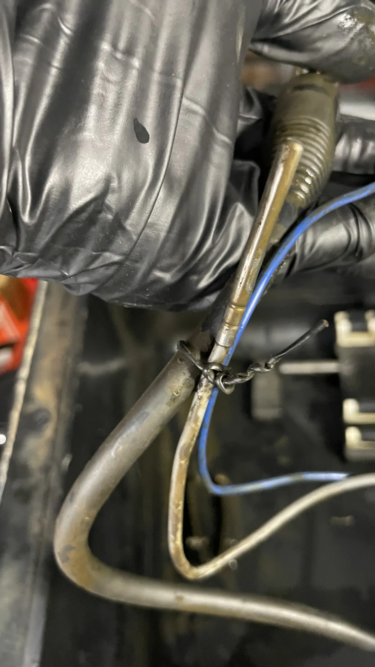 Close-up of bare, twisted wiring joints near the bath heater, with visible oxidation